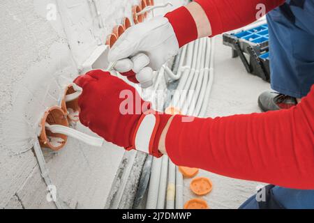House Interior Wall Power Sockets Installation Performed by Professional Electrician. Line of Electric Plug Sockets. Stock Photo