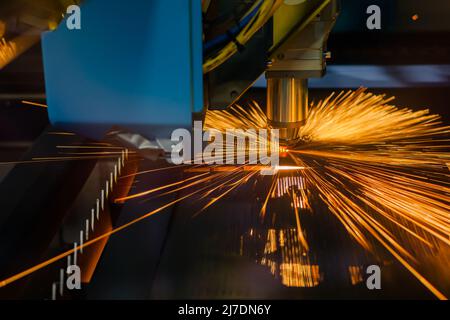 CNC laser cutting machine working with sheet metal with sparks Stock Photo