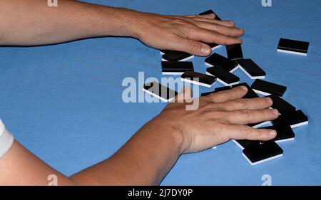 man's hands moving dots of the domino game Stock Photo