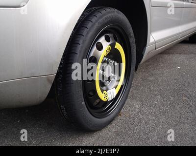 Temporary space saver spare wheel in use on Audi A3 after puncture Stock Photo