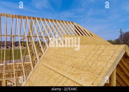 Installation of wooden beams at construction the assembled roof on house Stock Photo