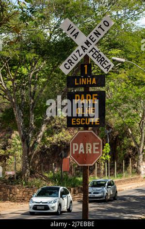 Level crossing signs warning nearby Tiradentes railway station advising to 'Stop, look and listen' before crossing the train tracks. Stock Photo