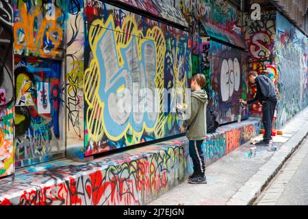 Graffiti artists at work on street art in Rutledge Lane, Melbourne, Victoria, Australia on Friday, April 15, 2022.Photo: David Rowland / One-Image.com Stock Photo