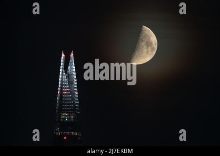 London, UK. 9th May, 2022. UK Weather: Moonset over The Shard skyscraper. A 51.7% first quarter moon continues to set over the city in the early hours of Monday moving in a north westerly direction. Credit: Guy Corbishley/Alamy Live News Stock Photo