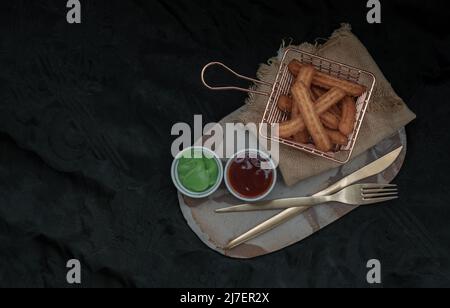 Traditional spanish churros sticks (Fried-dough pastry) Served usually with Thai pandan custard and Ketchup. Breakfast everywhere in Spain, Top view, Stock Photo