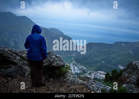 Rear view of woman standing on the top of the hill on a rainy day Stock Photo