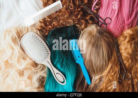 Image of assorted wigs of different styles and colors included dyed, curly and natural hair styles and hairdresser tools Stock Photo