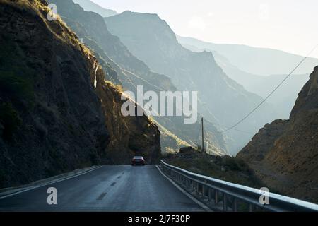 car running on highway through the rocky mountains in sichuan province, china Stock Photo