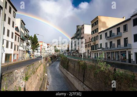 FUNCHAL, MADEIRA ISLAND - February 20, 2022: Funchal city street after the rain with a beautiful rainbow Stock Photo