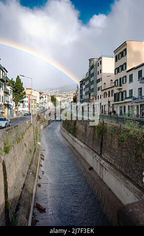 FUNCHAL, MADEIRA ISLAND - February 20, 2022: Funchal city street after the rain with a beautiful rainbow Stock Photo