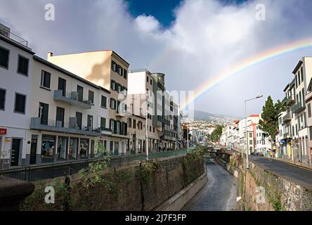 FUNCHAL, MADEIRA ISLAND - February 20, 2022: Funchal city street after the rain with a beautiful rainbow Stock Photo