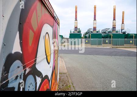 Artwork on Mega munch cafe on industrial site with waste incinerators in background Stock Photo