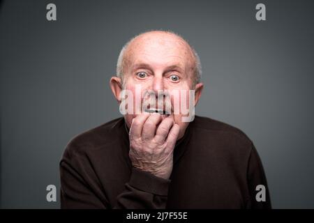 Senior man lonely at home, anxious/afraid to go out - self isolation/ quarantine due to COVID-19/ Coronavirus social distancing/prevention concept Stock Photo