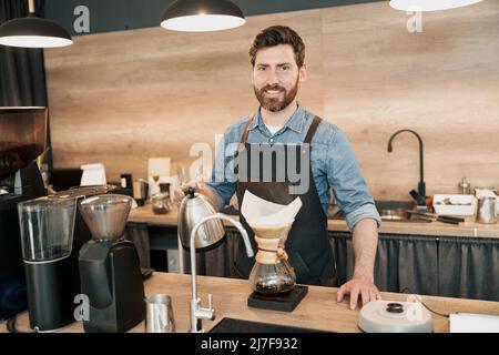 Man barista making filter coffee in cafeteria Stock Photo