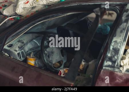 front part of a damaged car full of trash. High quality photo
