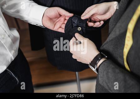 Two Men checking the quality of the suit fabric in a men's clothing store. Men's suit, tailor in his workshop. Stock Photo