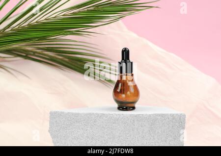 Natural hyaluronic serum in bottles with pipette. Natural essential oil or serum in a bottle with a pipette on a gray podium. Stock Photo