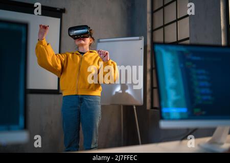 Schoolgirl wearing virtual reality goggles at school in computer science class Stock Photo
