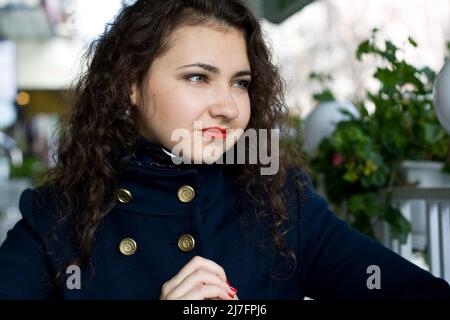 Young beautiful brunette in a street cafe Stock Photo