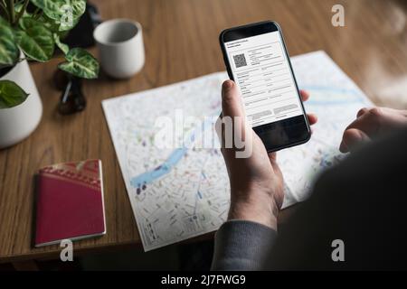 Man holding smart phone with covid-19 certificate Stock Photo