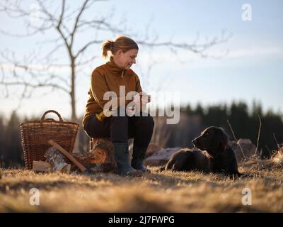 Woman and dog taking break from outdoor work Stock Photo