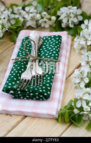 Two forks on rustic wooden background and branches with flowers Stock Photo