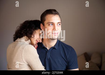 Smiling young couple hugging at home Stock Photo