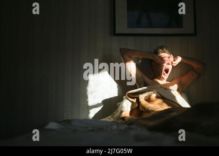 Man waking up in bed Stock Photo