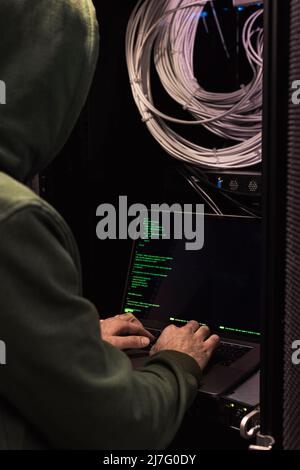 IT technician working on laptop in server room Stock Photo