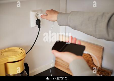 Hands plugging in cell phone charger Stock Photo