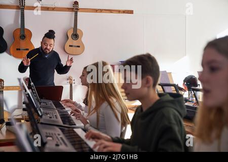 Teenagers attending keyboard lesson Stock Photo