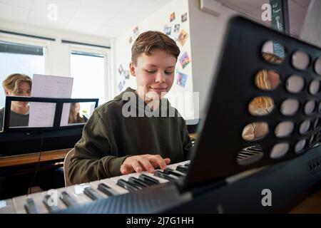 Teenagers attending keyboard lesson Stock Photo