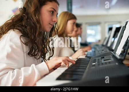 Teenagers attending keyboard lesson Stock Photo