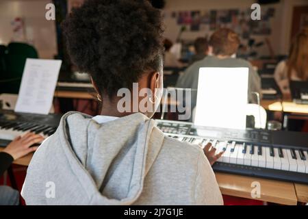 Teenagers attending keyboard lesson Stock Photo