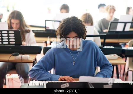 Teenagers attending keyboard lesson Stock Photo