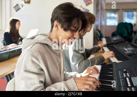 Teenagers attending keyboard lesson Stock Photo