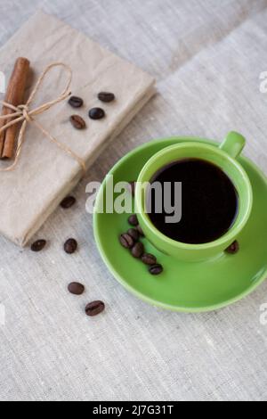 Green cup of coffee with coffee beans and vintage notebook Stock Photo