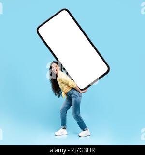 Excited lady holding heavy white empty smartphone screen Stock Photo