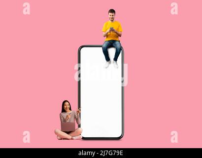 People sitting on white empty smartphone screen and using gadgets Stock Photo