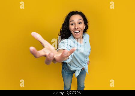 Excited young woman outstretching hand, trying to grab something Stock Photo