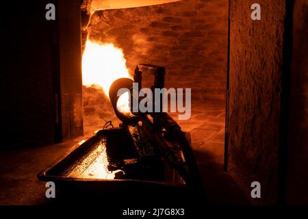 Close-up of a fire cannon warms up a brick oven with a huge flame for further baking in it. Stock Photo