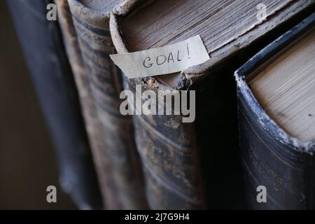 Goal, motivational concept. The inscription on the tag and retro books. Stock Photo