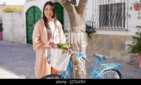 Charming multiethnic woman standing on city street and smiling Stock Photo