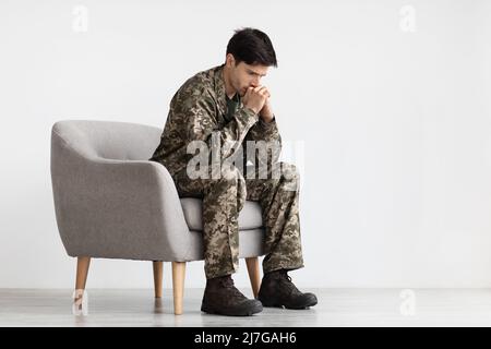 Depressed young military black covering his mouth with palms Stock Photo