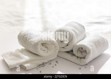 Close-up of a rolled white bath towels on a white background. Stock Photo