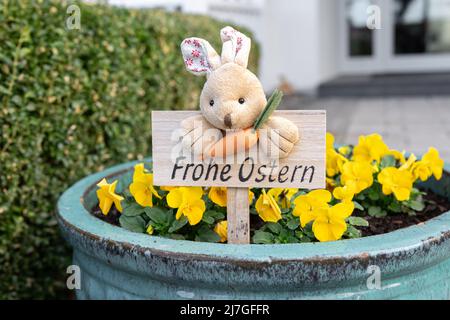 Sign with a rabbit and the inscription Happy Easter in German. Stock Photo