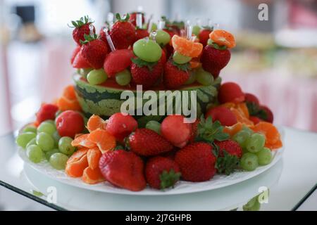 plate with berries strawberries raspberries and blueberries on a table in a restaurant Stock Photo