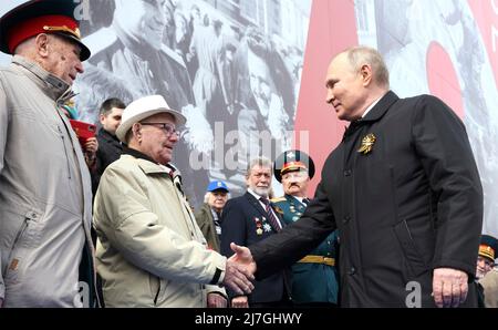 Moscow, Russia. 09th May, 2022. Russian President Vladimir Putin shakes hands with veterans at the start of the 77th annual Victory Day military parade celebrating the end of World War II at Red Square, May 9, 2022 in Moscow, Russia. Credit: Mikhail Metzel/Kremlin Pool/Alamy Live News Stock Photo