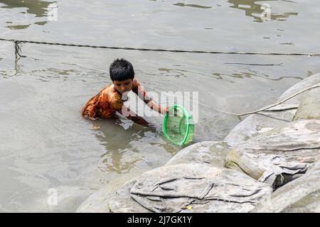 Satkhira, Bangladesh. 6th May, 2022. A child catches small fish by a basket in the Kholpatua river near the Sundarban forest at Shyamnagar in Satkhira district, Bangladesh. (Credit Image: © Piyas Biswas/SOPA Images via ZUMA Press Wire) Stock Photo