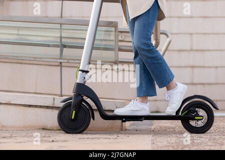 Close up low view of young woman legs and feets wearing jeans and sneakers around the city. City life concept Stock Photo